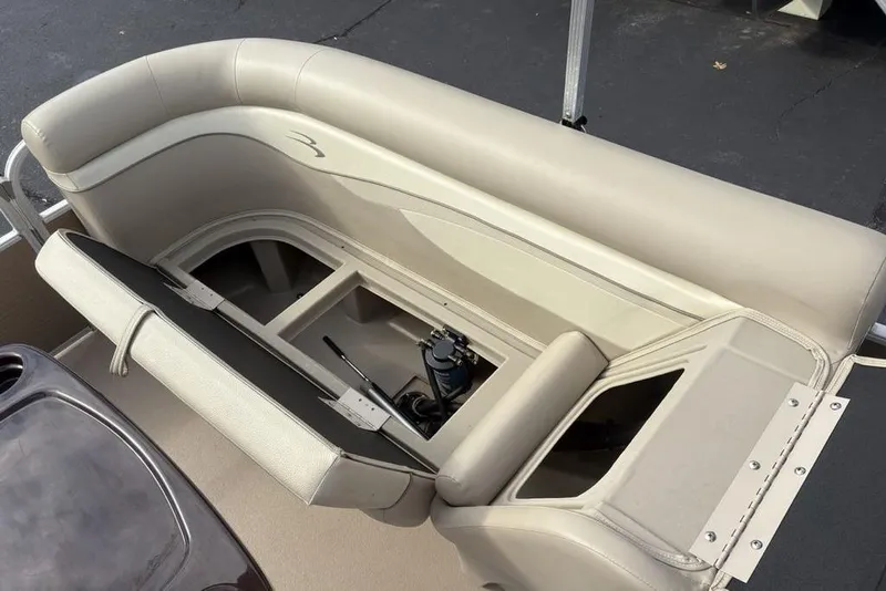 Slide: The Image of 2015 Bennington 24 SSRX boat interior with beige seating and storage compartments. - 19