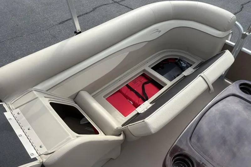 Slide: The Image of 2015 Bennington 24 SSRX boat seat storage with red life jacket and battery compartment. - 26