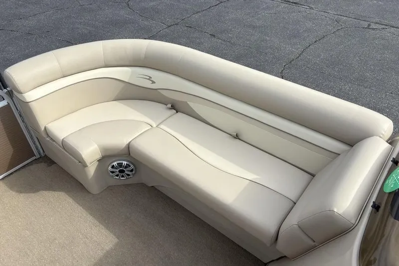Slide: The Image of Luxurious beige seating on 2015 Bennington 24 SSRX pontoon boat, featuring integrated speaker. - 7