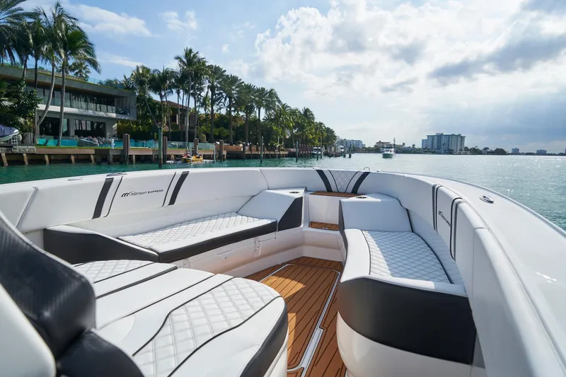 Slide: The Image of 2020 Midnight Express 37' Open boat with luxurious seating, cruising near waterfront homes. - 9