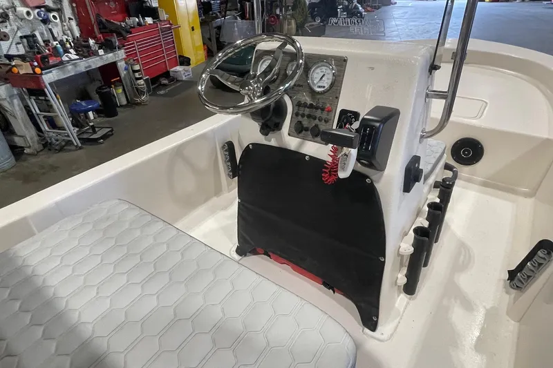 Slide: The Image of 2026 Carolina Skiff E18 JVX CC boat interior with steering wheel and control panel. - 7