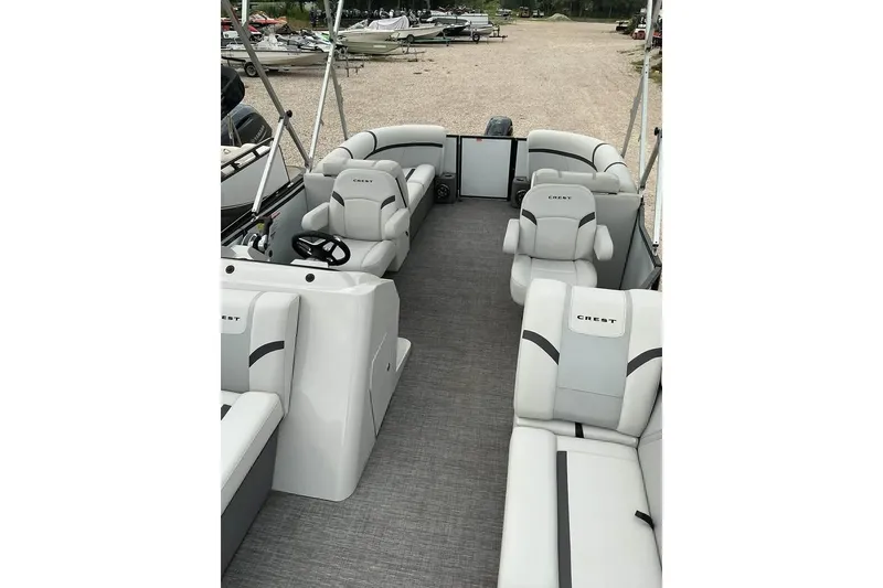 Slide: The Image of 2023 Crest Classic LX 220 pontoon boat interior with plush seating and steering console. - 10