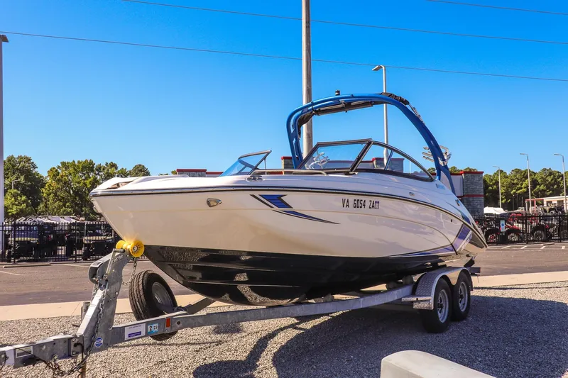 The Image of 2019 Yamaha Boats 212X on trailer, parked outdoors under clear blue sky. - 1