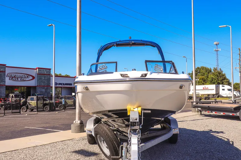 Slide: The Image of 2019 Yamaha Boats 212X on trailer at dealership, clear blue sky background. - 2