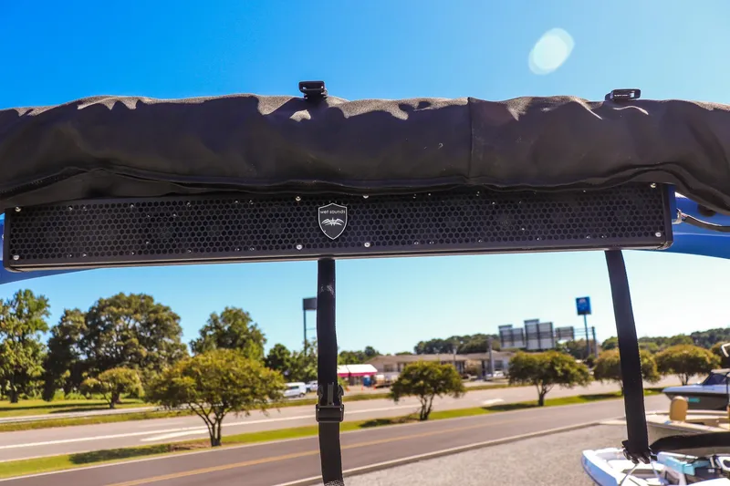 Slide: The Image of 2019 Yamaha Boats 212X with Wet Sounds speaker, sunny day, road and trees in background. - 20