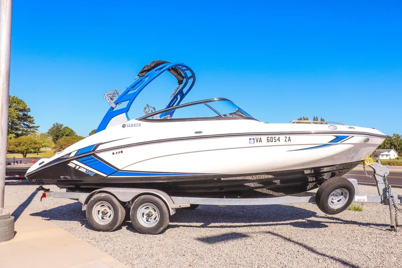 Slide: The Image of 2019 Yamaha Boats 212X on trailer, displayed outdoors under clear blue sky. - 4