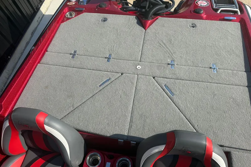 Slide: The Image of 2023 Bass Cat Jaguar STS boat deck with gray carpet and red-accented seats. - 10