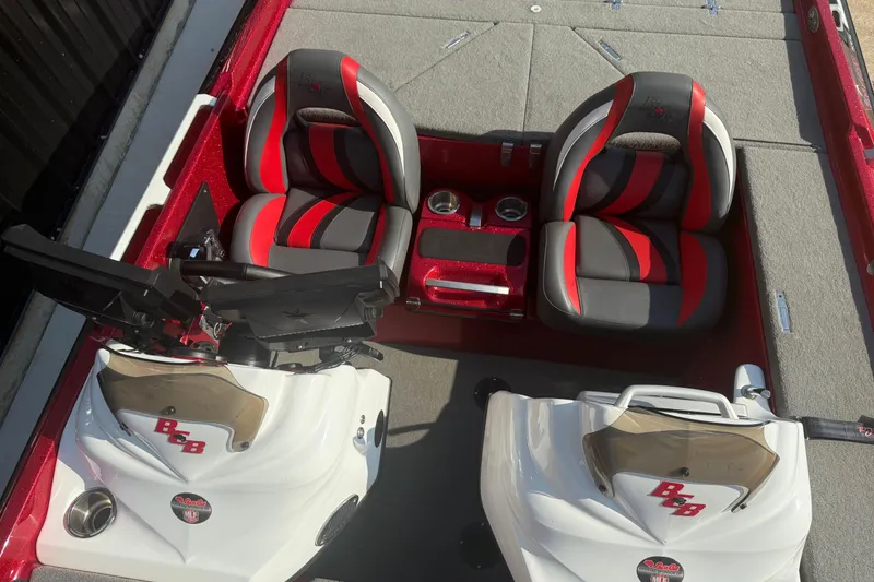Slide: The Image of 2023 Bass Cat Jaguar STS boat interior with red and gray seats, dual consoles. - 7