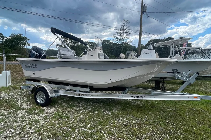 The Image of 2026 Carolina Skiff 19 LS boat on trailer, parked outdoors under cloudy sky. - 1