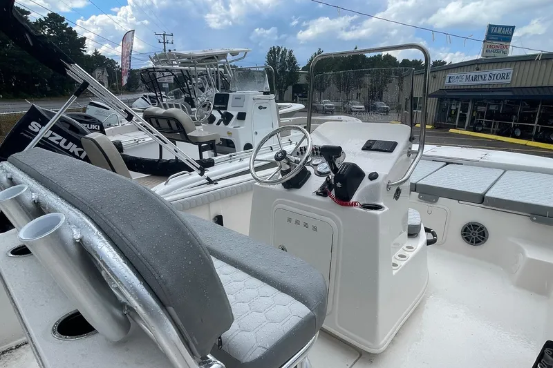 Slide: The Image of 2026 Carolina Skiff 19 LS boat interior with steering console and seating, displayed outdoors. - 5