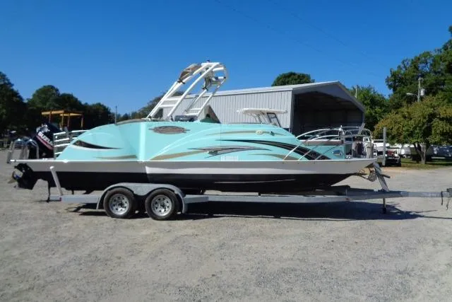 Slide: The Image of 2018 Caravelle Razor 238 PF boat on trailer, parked outdoors under clear blue sky. - 2