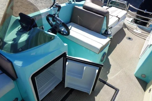 Slide: The Image of 2018 Caravelle Razor 238 PF boat interior with open mini-fridge and seating area. - 27