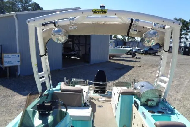 Slide: The Image of 2018 Caravelle Razor 238 PF boat with canopy and seating, parked outdoors. - 28