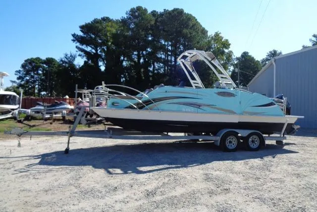 Slide: The Image of 2018 Caravelle Razor 238 PF boat on trailer, parked outdoors near trees and a building. - 7
