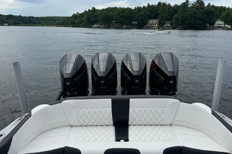 Slide: The Image of 2022 Nor-Tech 390 Sport Center Console with four powerful outboard engines on a serene lake. - 11