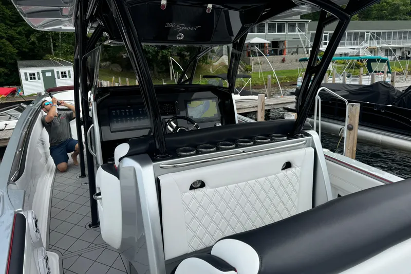 Slide: The Image of 2022 Nor-Tech 390 Sport Center Console boat interior at dock, featuring modern controls. - 14