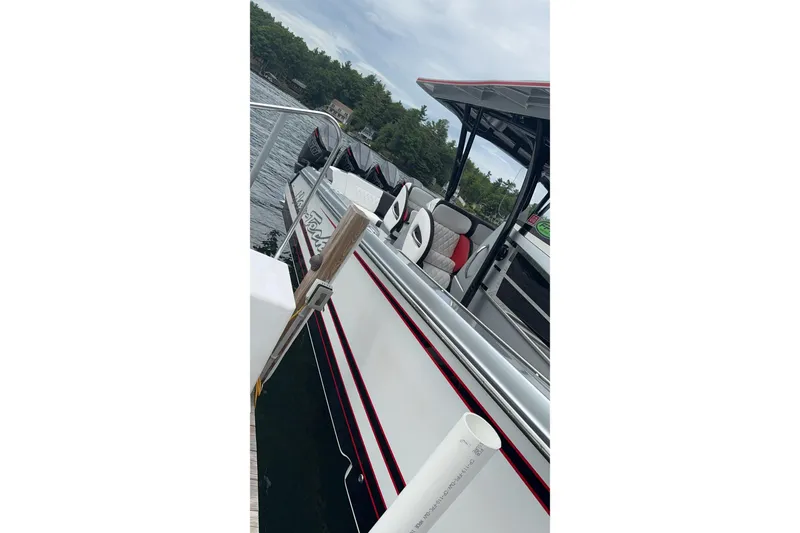 Slide: The Image of 2022 Nor-Tech 390 Sport Center Console docked by a lake with lush greenery. - 17