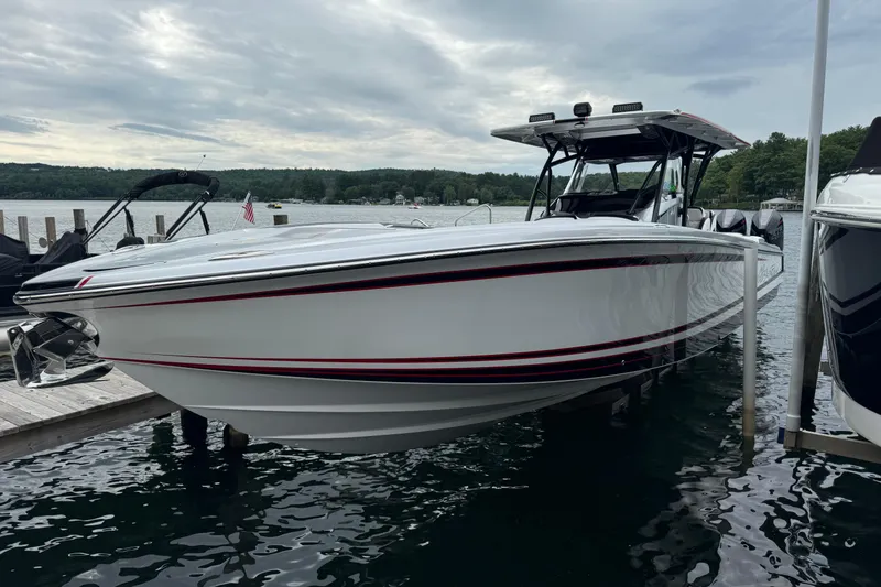 Slide: The Image of 2022 Nor-Tech 390 Sport Center Console boat docked on a serene lake. - 19