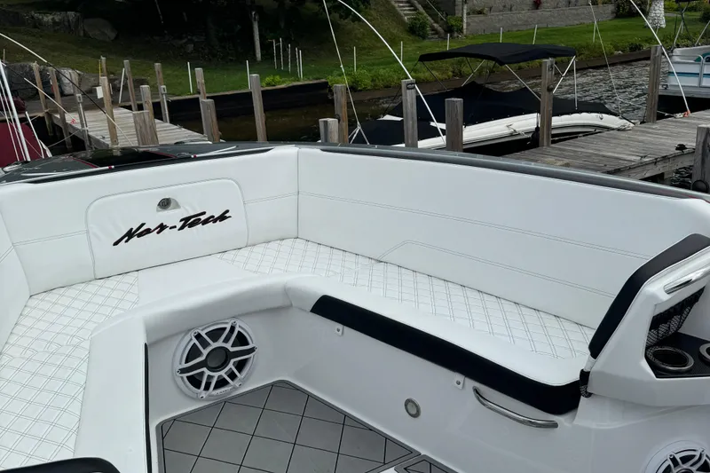 Slide: The Image of 2022 Nor-Tech 390 Sport Center Console with white seating and speaker, docked at marina. - 7