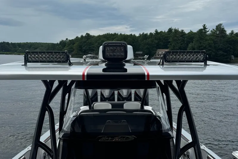 Slide: The Image of 2022 Nor-Tech 390 Sport Center Console boat with advanced lighting, on a serene lake. - 8