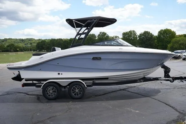 Slide: The Image of 2026 Sea Ray SPX 210 boat on trailer, parked outdoors with trees in background. - 4