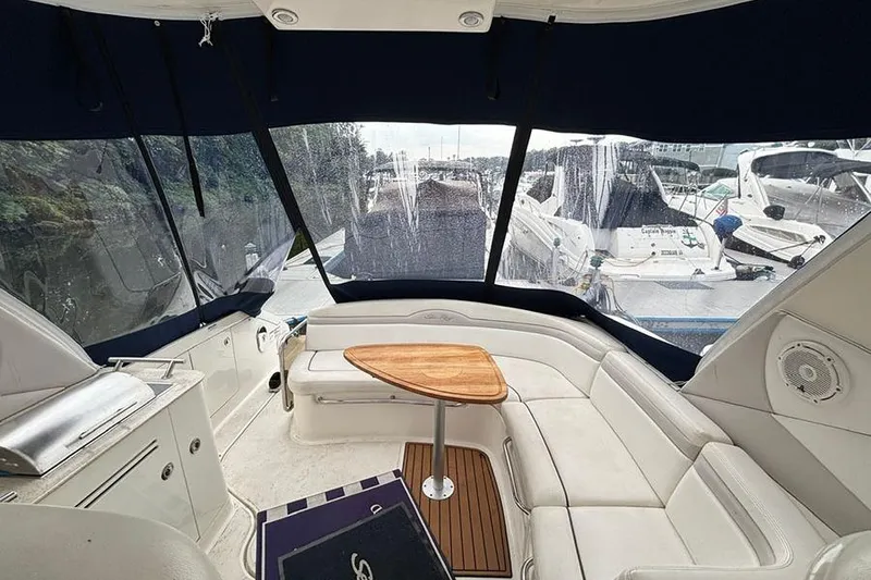 Slide: The Image of Interior of 2011 Sea Ray 370 Sundancer yacht with white seating and wooden table. - 11