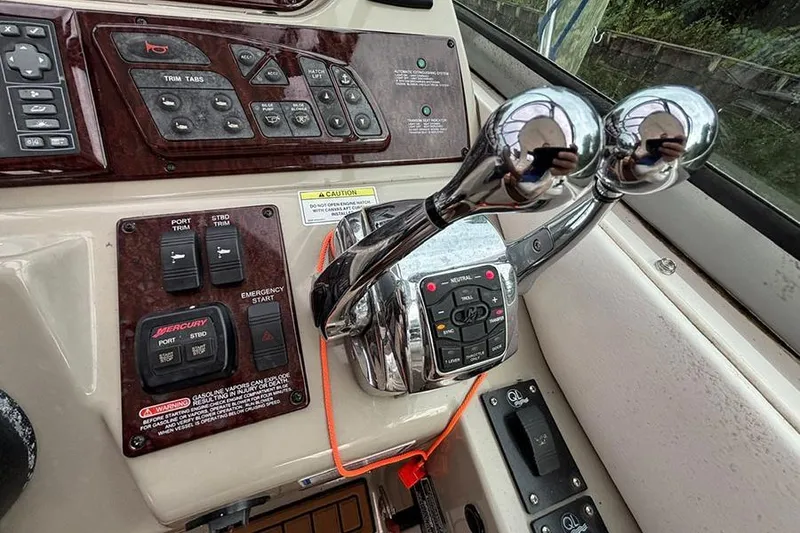 Slide: The Image of Control panel of a 2011 Sea Ray 370 Sundancer boat with throttle levers. - 13