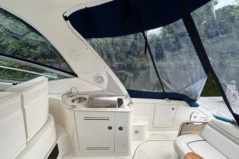 Slide: The Image of 2011 Sea Ray 370 Sundancer boat interior with kitchenette and seating area. - 14