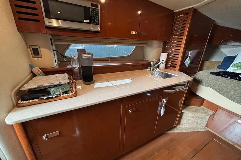 Slide: The Image of Interior of 2011 Sea Ray 370 Sundancer yacht with kitchenette and cozy cabin. - 23