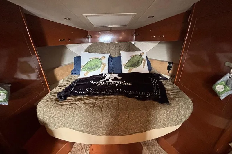 Slide: The Image of Cozy cabin interior of 2011 Sea Ray 370 Sundancer with decorative pillows and blanket. - 29