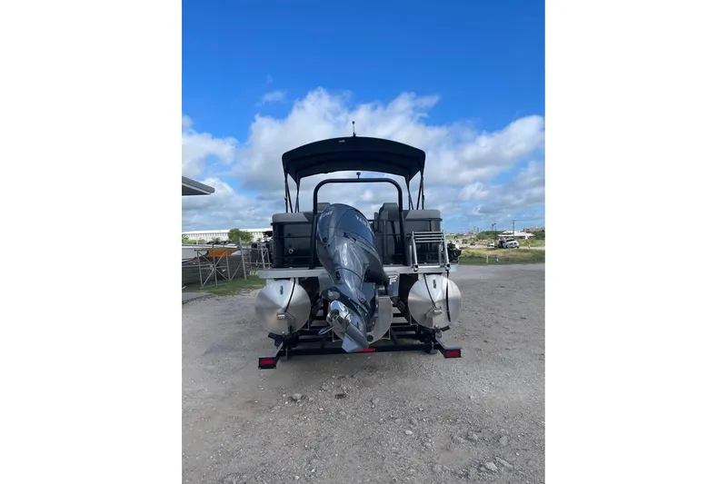 Slide: The Image of 2024 Veranda Relax VR22RC pontoon boat with outboard motor, parked on gravel. - 3