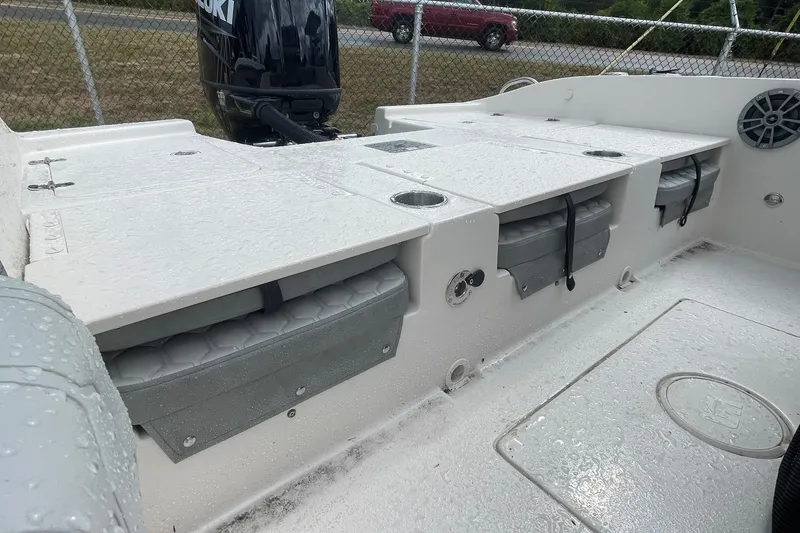 Slide: The Image of 2026 Carolina Skiff 22 Ultra Elite boat interior with storage compartments and Suzuki outboard motor. - 16