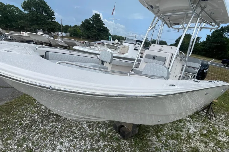 Slide: The Image of 2026 Carolina Skiff 22 Ultra Elite boat displayed outdoors on a stand. - 2