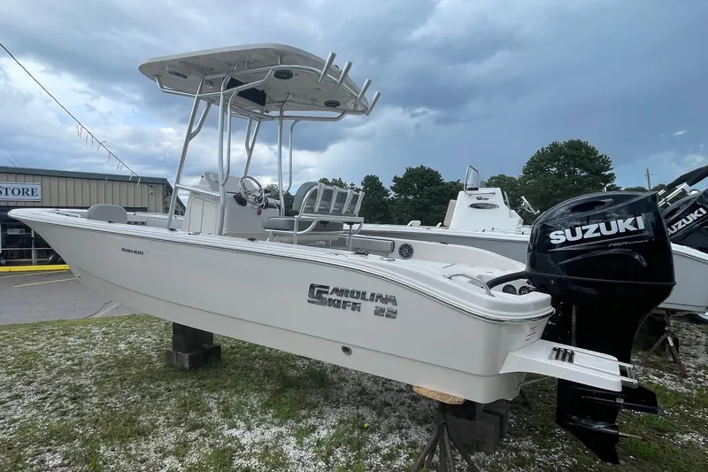 Slide: The Image of 2026 Carolina Skiff 22 Ultra Elite boat with Suzuki outboard motor displayed outdoors. - 5