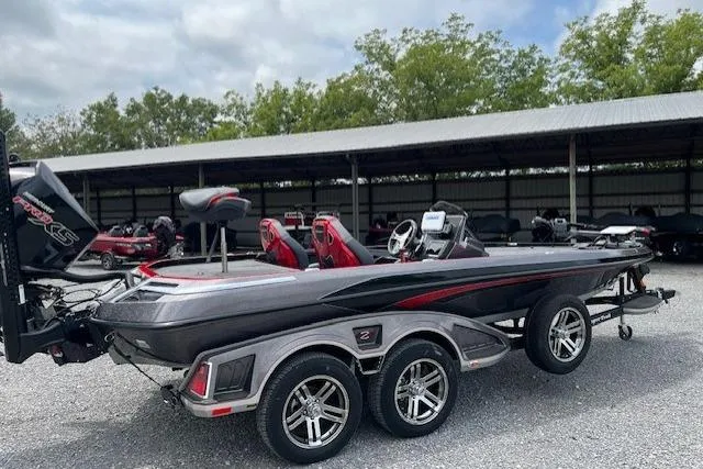 Slide: The Image of 2024 Ranger Z521R boat with dual axle trailer, parked outdoors under a canopy. - 4