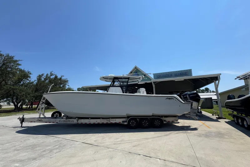 Slide: The Image of 2021 Invincible 35' Catamaran on trailer, side view under cloudy sky. - 1