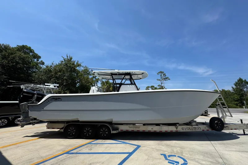Slide: The Image of 2021 Invincible 35' Catamaran on trailer, parked outdoors under a clear sky. - 10