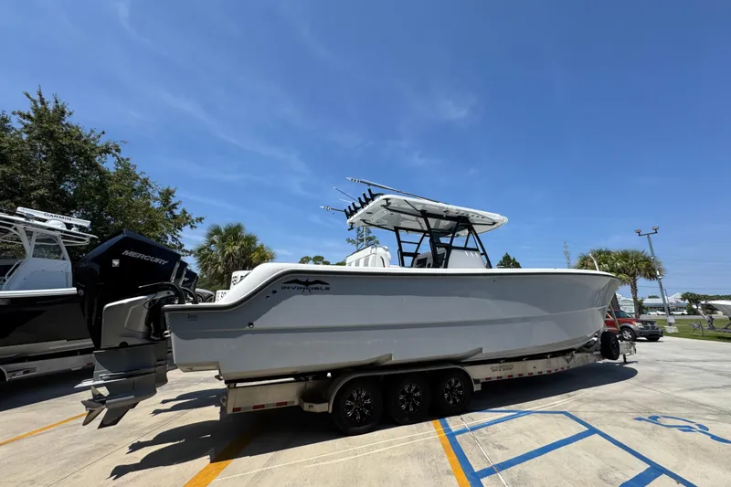 Slide: The Image of 2021 Invincible 35' Catamaran on trailer, parked outdoors under blue sky. - 11