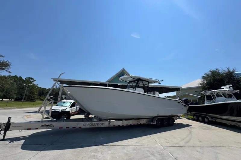 Slide: The Image of 2021 Invincible 35' Catamaran on trailer, parked outdoors under cloudy sky. - 3