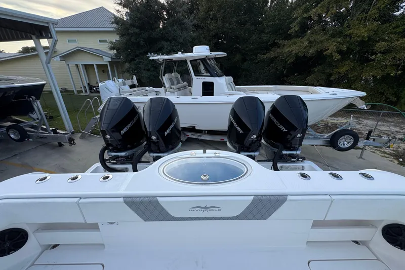 Slide: The Image of 2021 Invincible 35' Catamaran with four Mercury outboard engines, parked near a house. - 39