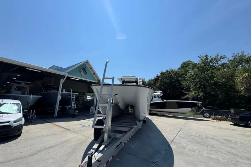 Slide: The Image of 2021 Invincible 35' Catamaran on trailer at dealership, under a cloudy sky. - 6
