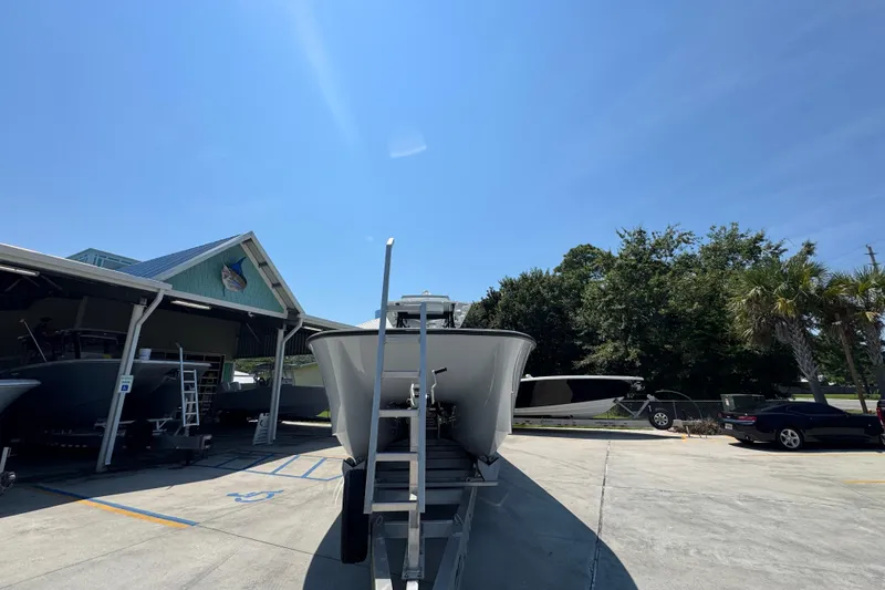 Slide: The Image of 2021 Invincible 35' Catamaran on trailer at dealership, under a cloudy sky. - 7