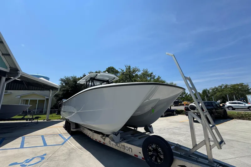 Slide: The Image of 2021 Invincible 35' Catamaran on trailer, parked outdoors under a blue sky. - 8