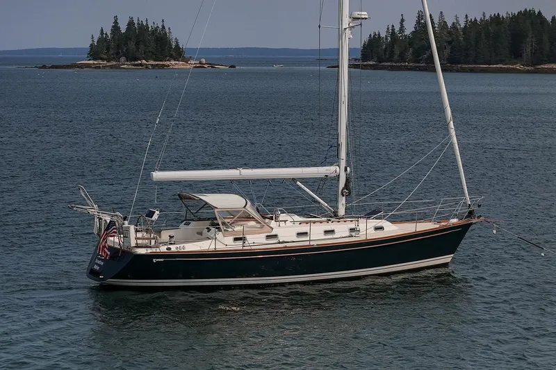 The Image of Sailboat Tartan 4100 (2002) anchored near forested island in calm waters. - 0