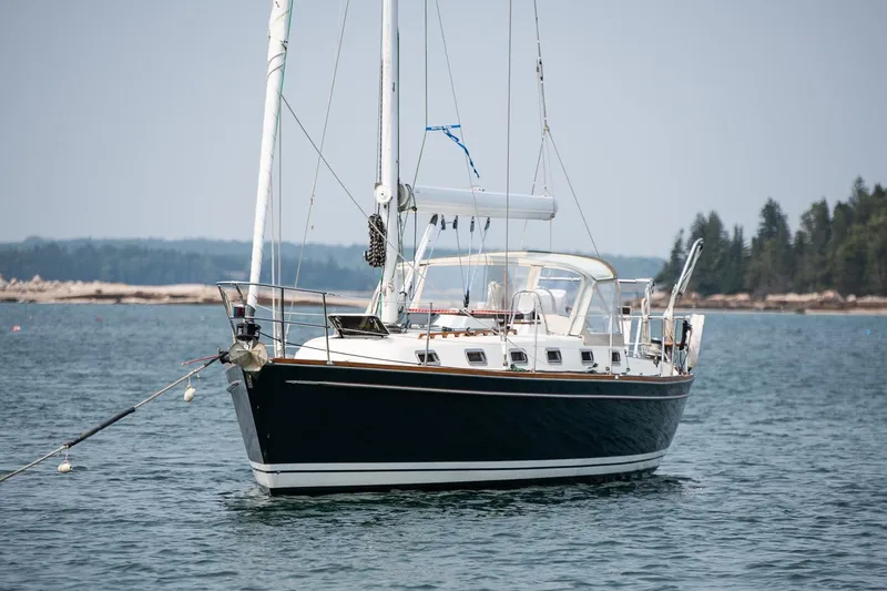 Slide: The Image of Sailboat Tartan 4100, 2002 model, anchored in calm waters with forested shoreline. - 11