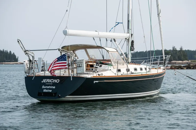 Slide: The Image of Sailboat Tartan 4100, 2002 model, named Jericho, anchored in calm waters with American flag. - 12