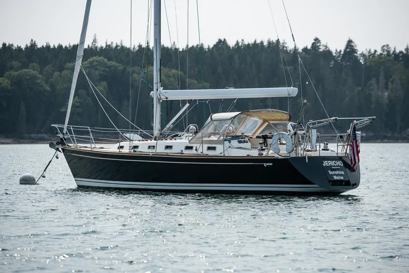 Slide: The Image of Sailboat Tartan 4100, 2002 model, anchored on calm water with forested background. - 15