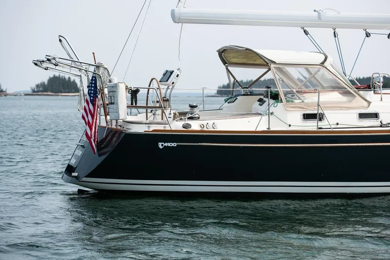 Slide: The Image of Sailboat Tartan 4100, 2002 model, anchored with American flag, calm waters. - 17