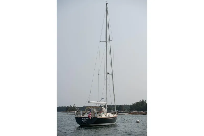 Slide: The Image of Sailboat Tartan 4100, 2002 model, anchored in calm waters with forested shoreline. - 18