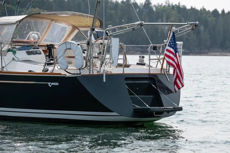 Slide: The Image of Sailboat Tartan 4100 (2002) with American flag on calm water. - 20